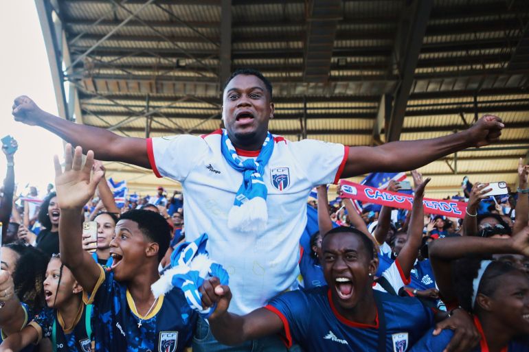 Fans celebrate in the stands after Cape Verde defeated Eswatini in a World Cup qualifying soccer match at Estádio Nacional in Praia, Cape Verde, Monday, Oct. 13, 2025, to clinch their qualification for the 2026 World Cup. (AP Photo/Cristiano Barbosa)