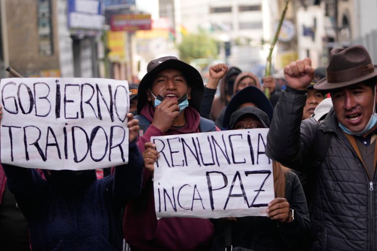 Anti-government protesters hold signs reading in Spanish "Resign Paz," and "Traitor government" referring to President Rodrigo Paz in La Paz, Bolivia, Monday, May 18, 2026