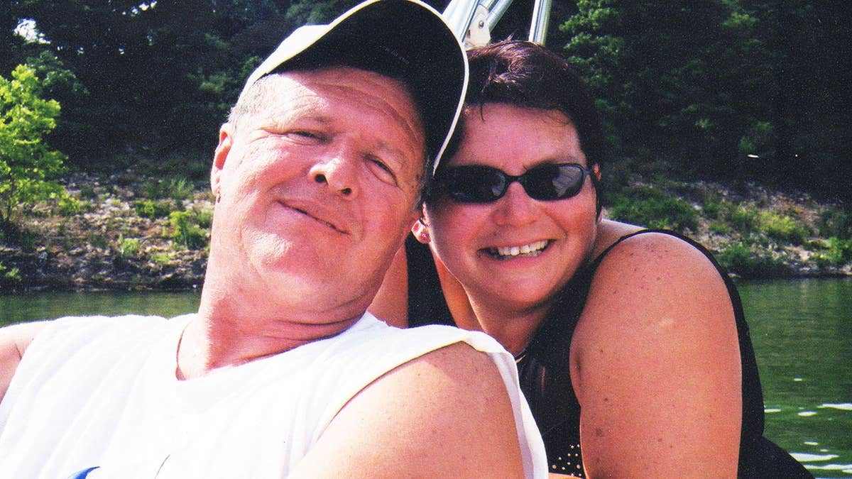 Jeff Walton wearing a white tank top leaning against a smiling Deb Proctor in a black tank top.
