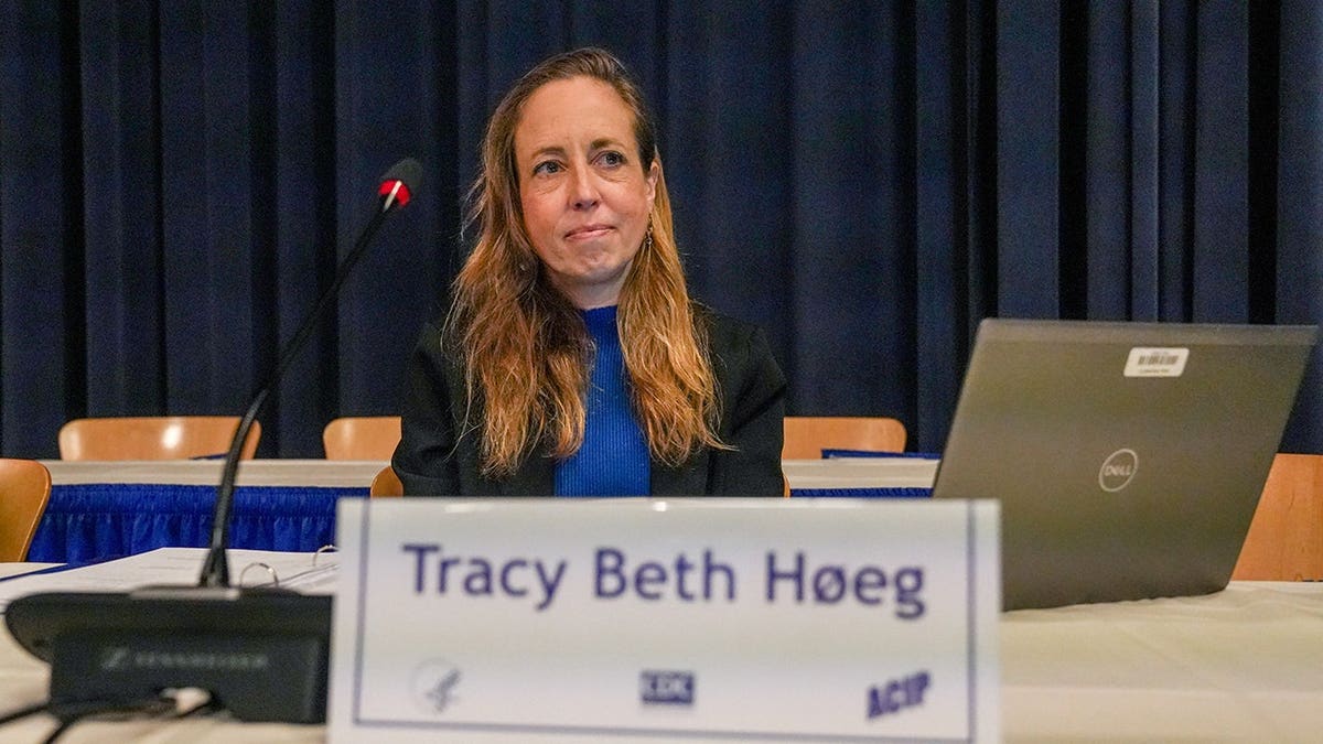 Dr. Tracy Beth Hoeg sits in front of a card bearing her name.