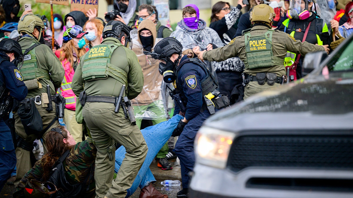 Federal agents detaining an anti-I.C.E. protester outside U.S. Immigration and Customs Enforcement building