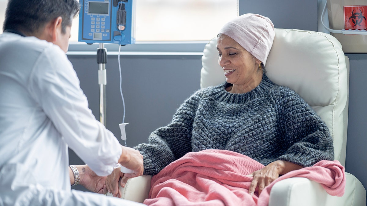 oncologist hooking up a woman battling cancer to an IV