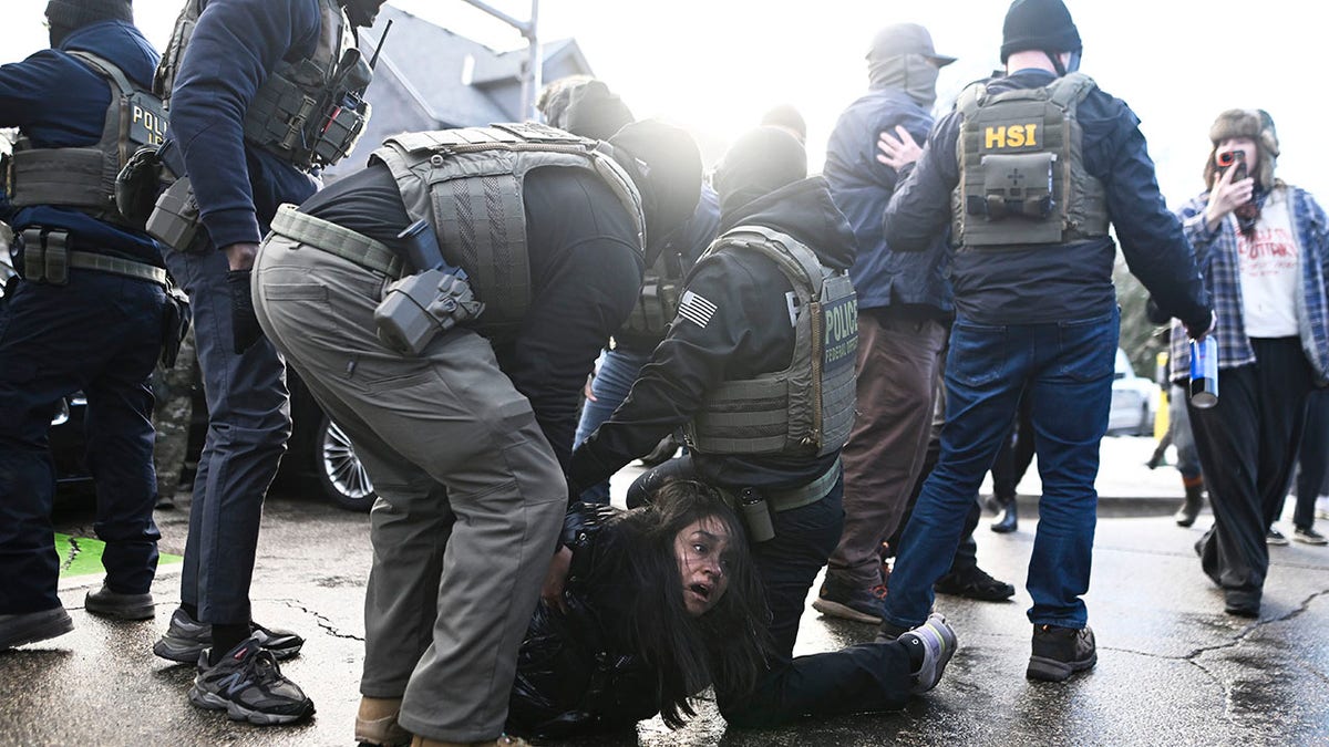 ICE agents detaining a woman pulled from a car in Minneapolis
