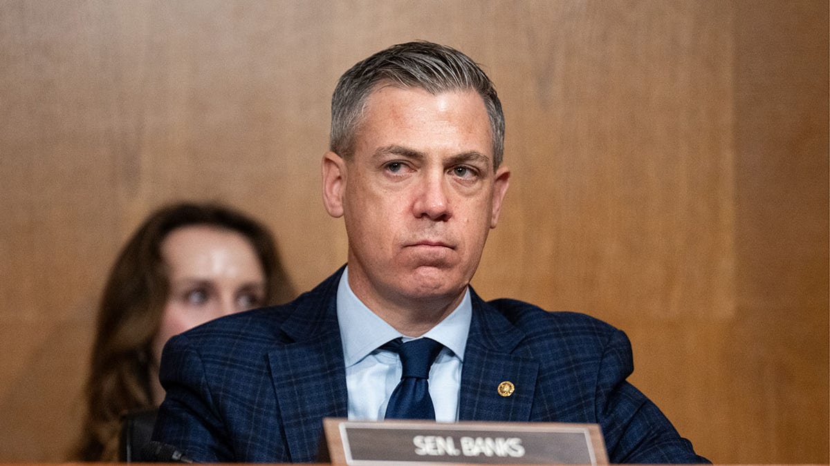 Sen. Jim Banks listening during a Senate committee confirmation hearing in a Senate office building