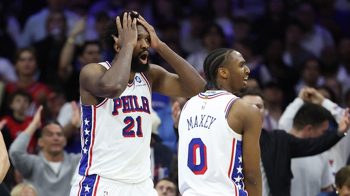 Joel Embiid reacting next to Tyrese Maxey during an NBA playoff game
