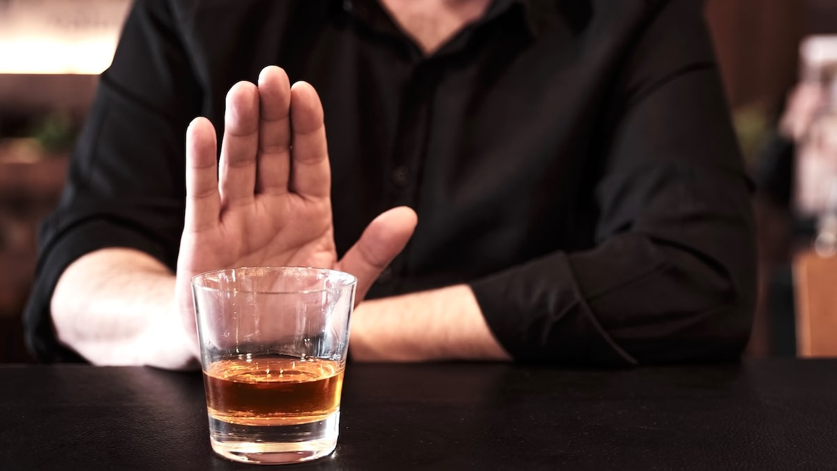 Man refusing to drink alcohol at a pub