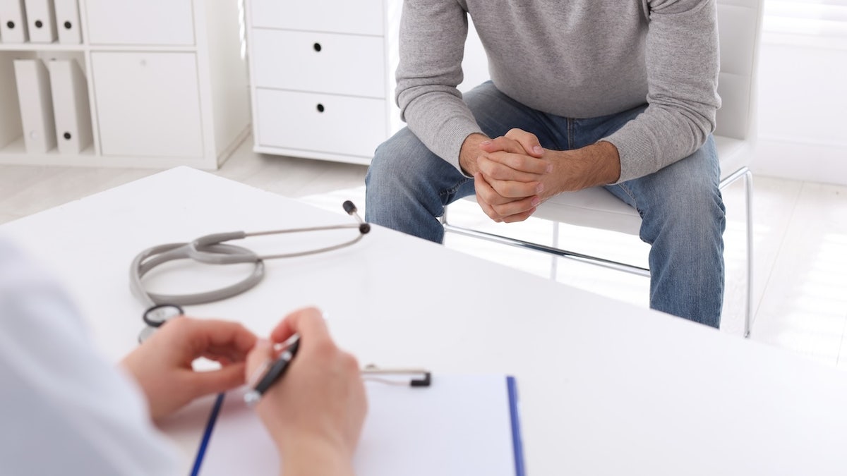 Man sitting in clinic during appointment with STD specialist