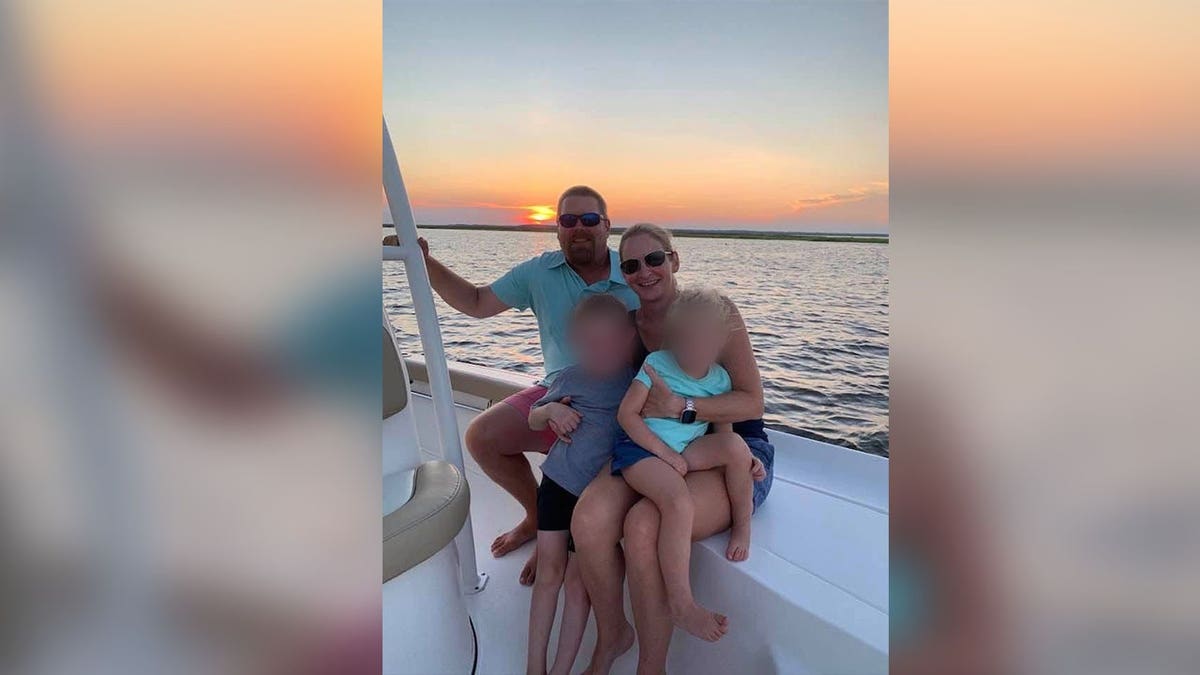 A family of four smiles on a boat.