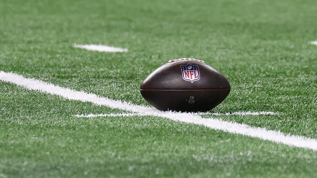 NFL game ball resting on turf at Ford Field before play