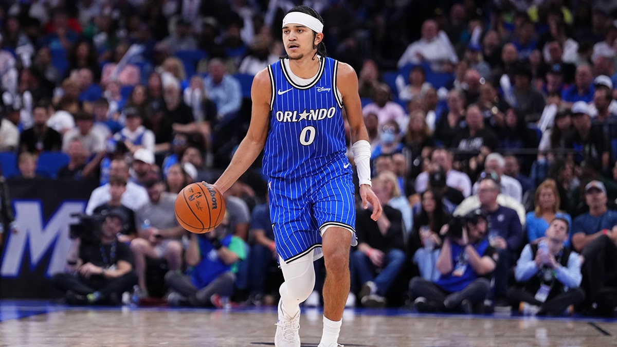 Anthony Black dribbling a basketball on the court during a game at Kia Center