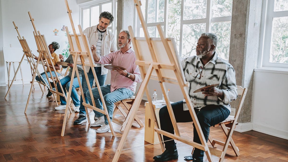 Seniors painting in an art class setting