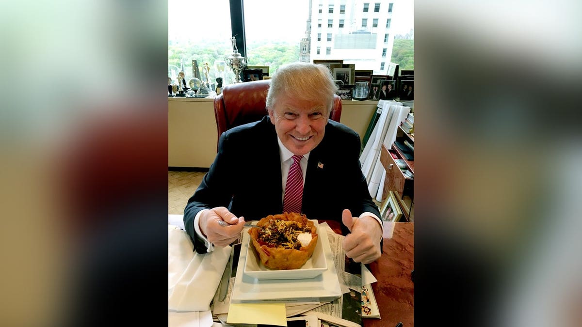 Trump smiling with taco bowl giving thumbs up.