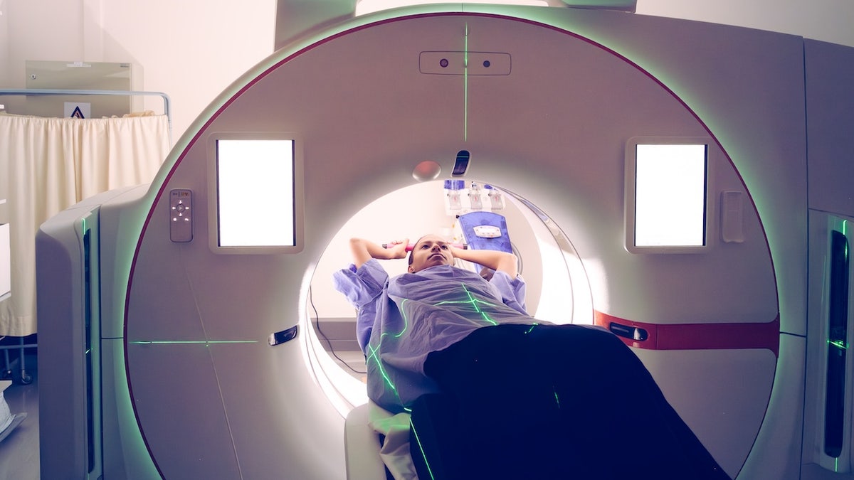 female undergoing diagnostic medical imaging with CT simulator in hospital