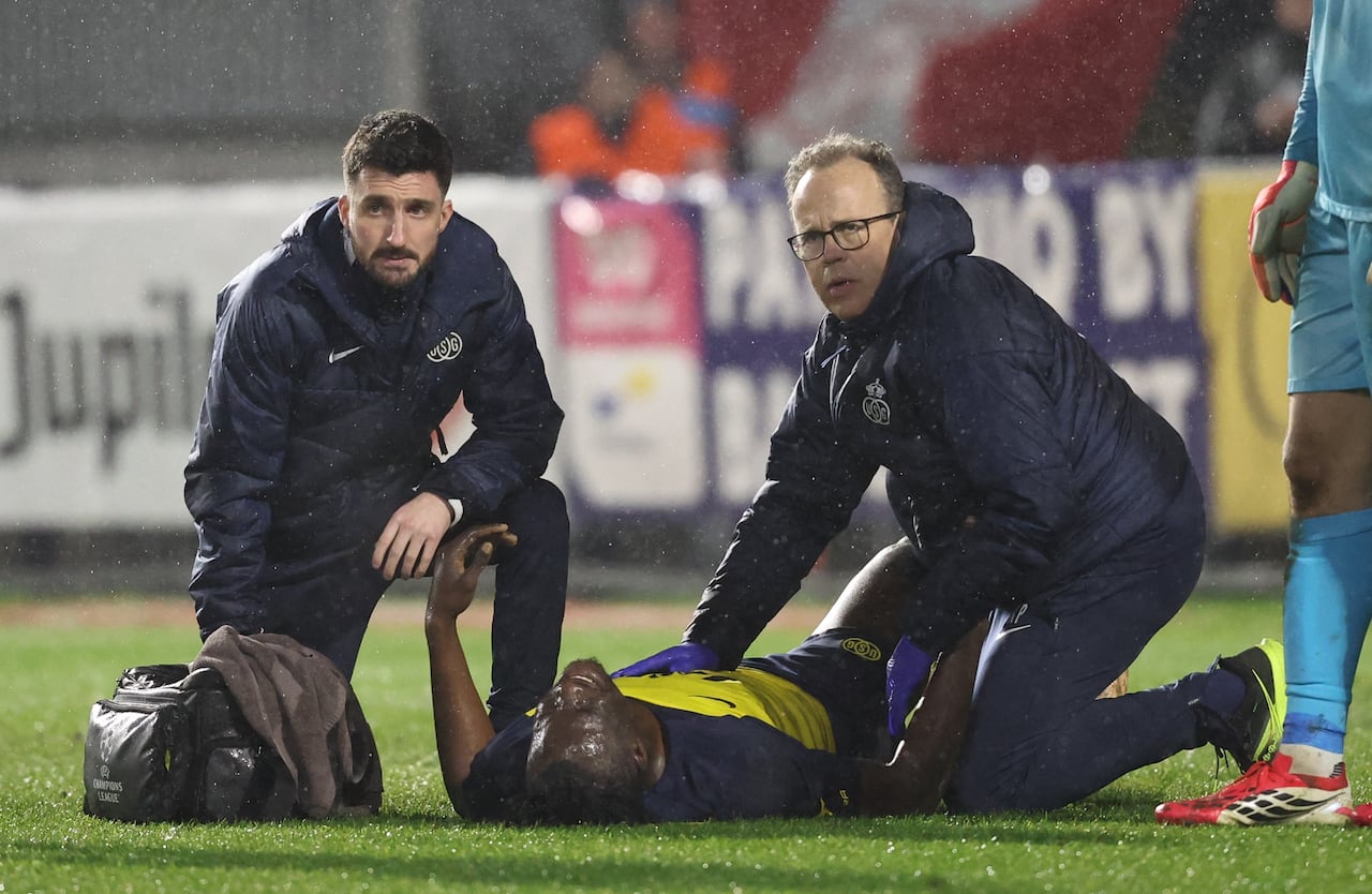 A soccer player lies injured on the field.