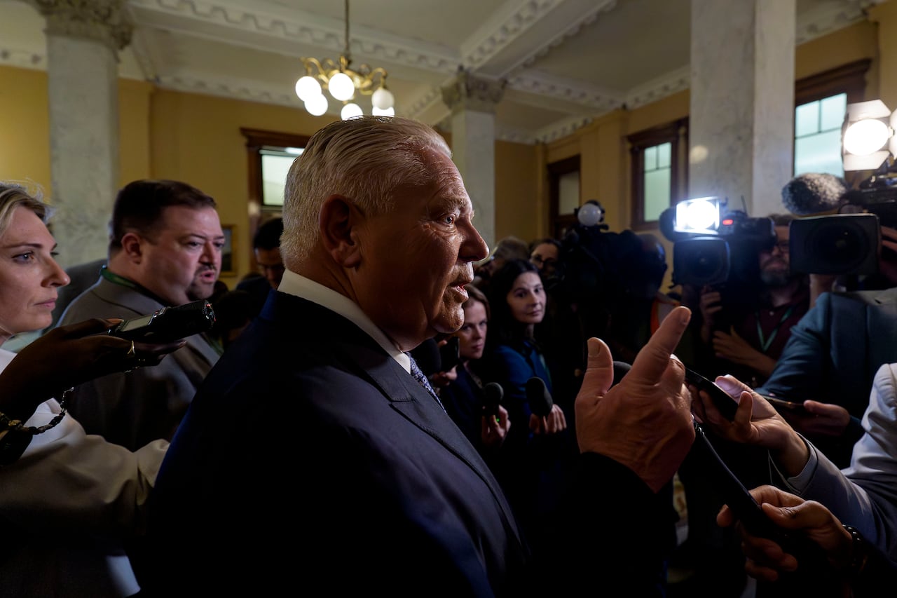 Premier Doug Ford is surrounded by reporters in the halls of Queen's Park