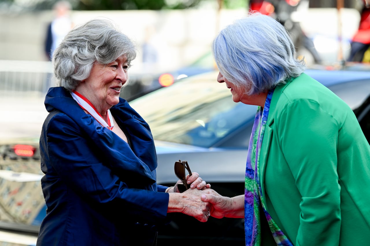 Two women shaking hands.