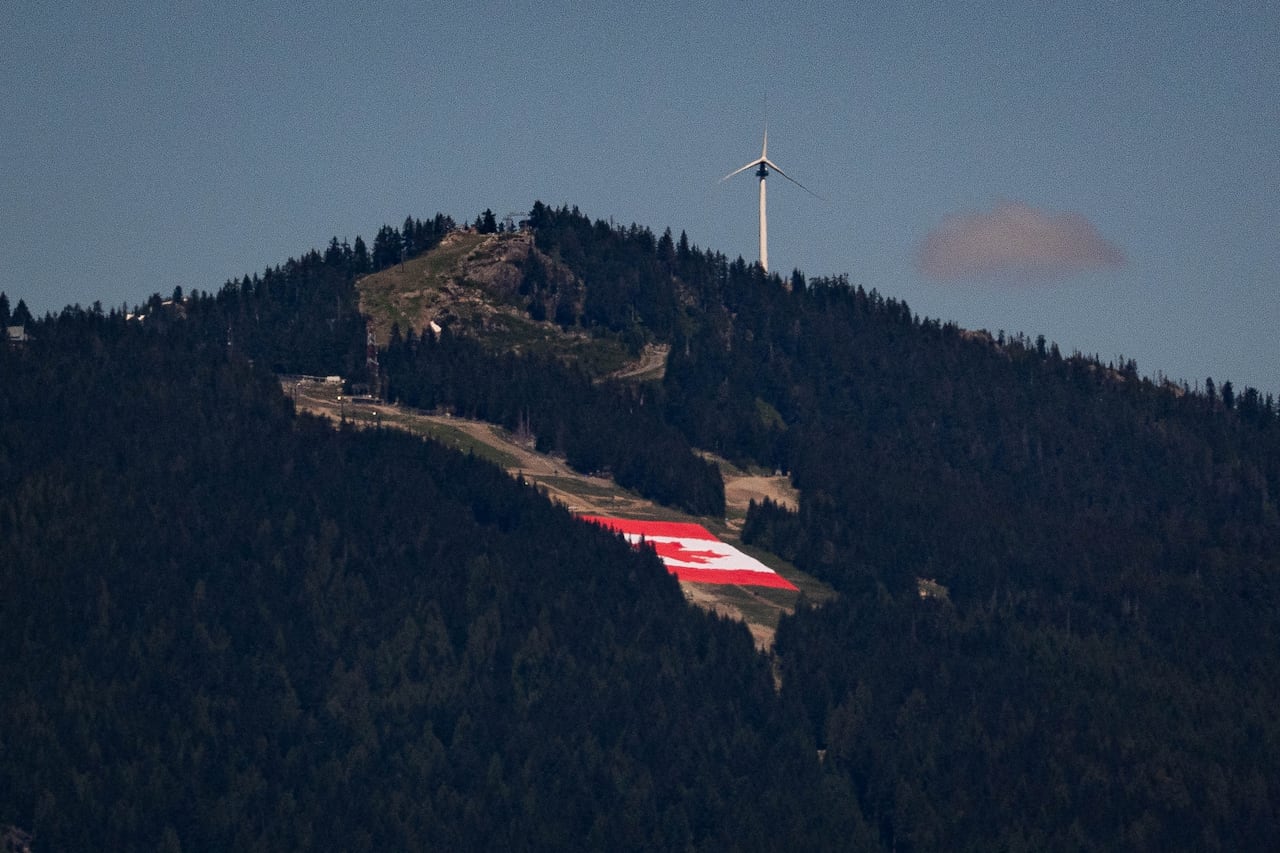 A giant Canada flag is unfurled on Grouse Mountain.