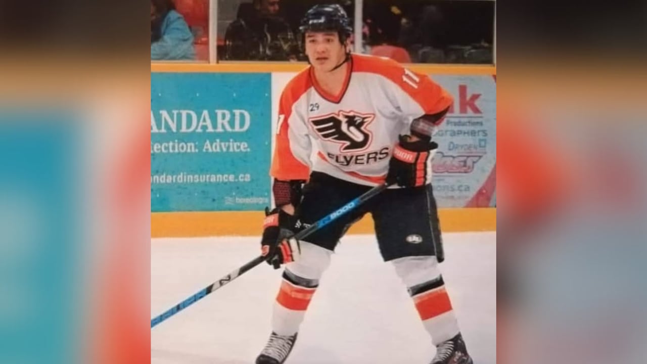 A person is seen playing hockey in an area.