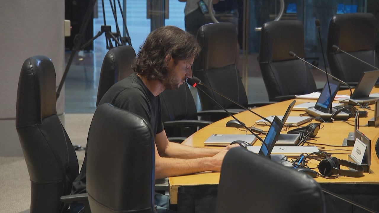 A man with long hair and a black shirt