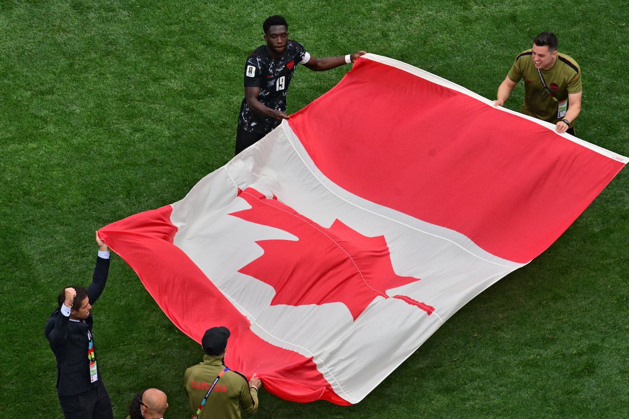 Soccer players display a flag.