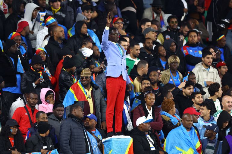 DR Congo fan Michel Nkuka Mboladinga poses as a statue of the country's independence hero Patrice Lumumba during the AFCON match against Algeria.