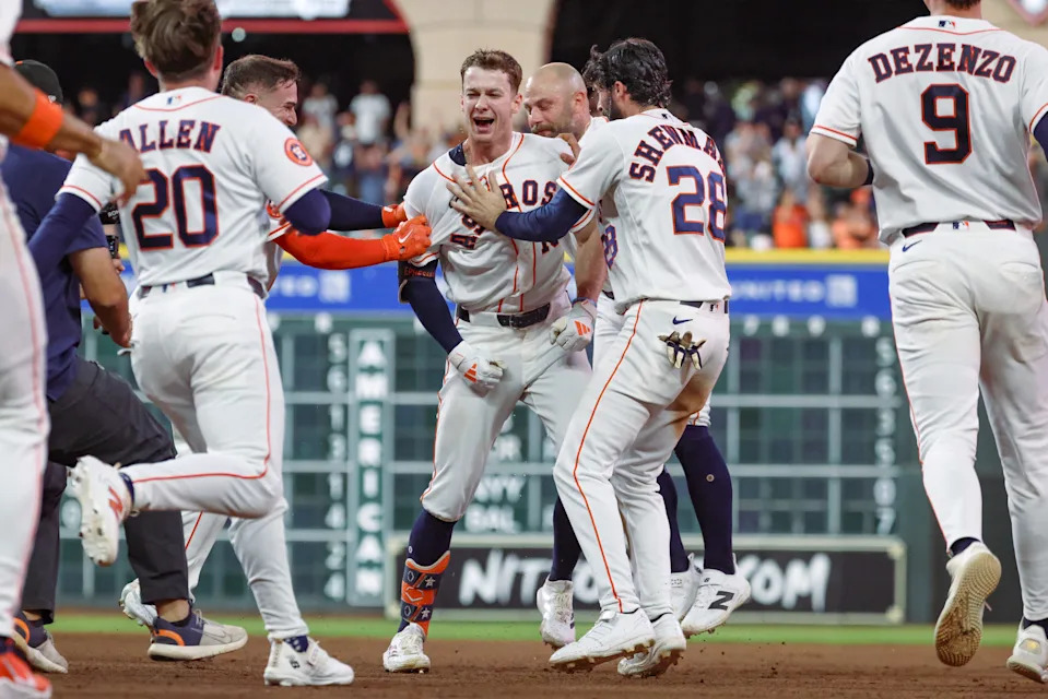 Houston Astros right fielder Zach Cole (16) is mobbed by teammates after his walk-off RBI single against the Seattle Mariners in an MLB game at Daikin Park in Houston, Texas.