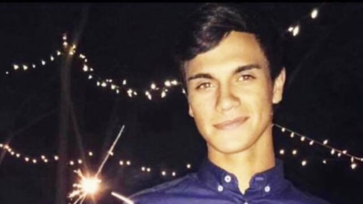 Emilio Valdez wearing a blue shirt holding a sparkler.