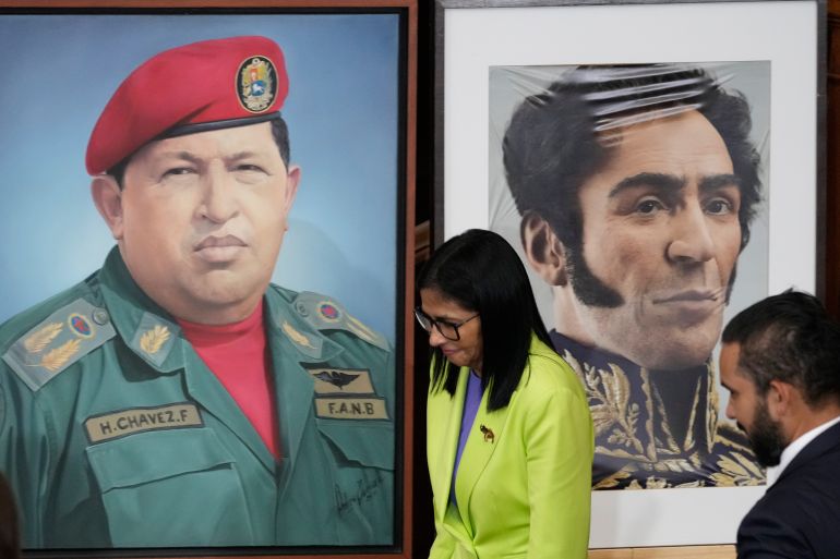 FILE - Venezuela's acting President Delcy Rodriguez walks past a image of former President Hugo Chavez, left, and Independence hero Simon Bolivar at the National Assembly in Caracas, Venezuela, Jan. 15, 2026. (AP Photo/Ariana Cubillos, File)