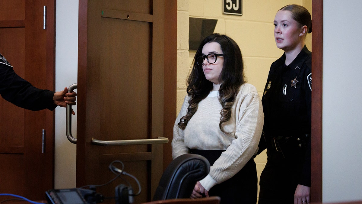 Juliana Peres Magalhães escorted into a courtroom in Fairfax, Virginia