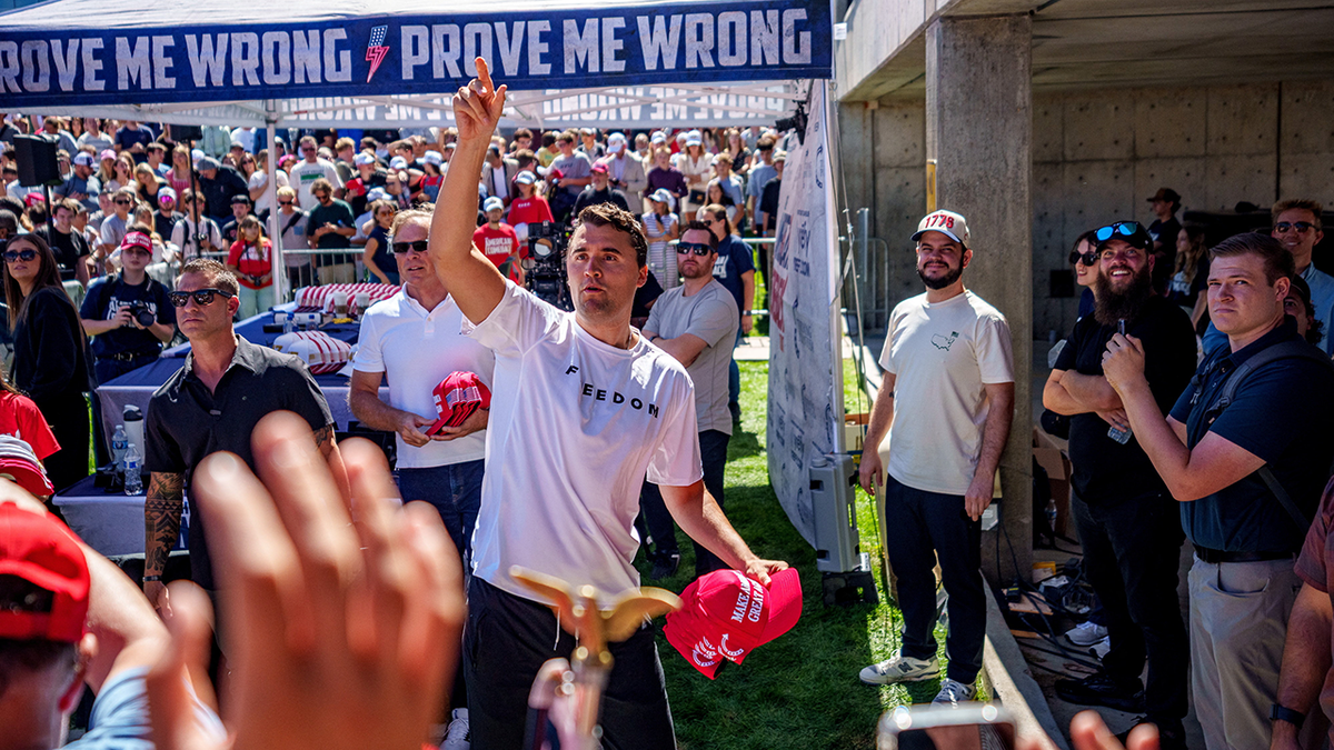 Charlie Kirk tossing hats to audience members at an event in Utah