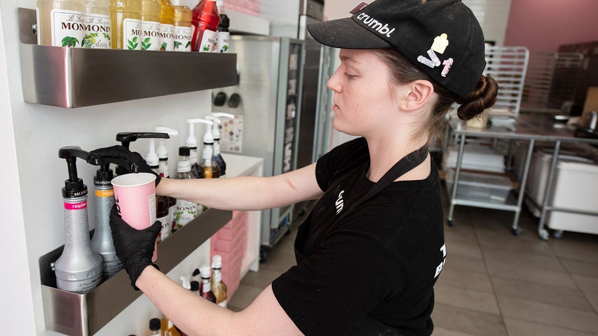 Kayleigh Crozier adding mango puree to a customized Dirty Soda at Crumbl in Newtown Township