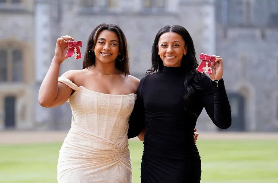 Becky and Ellie Downie hold MBE ribbons outside Windsor Castle in 2024.