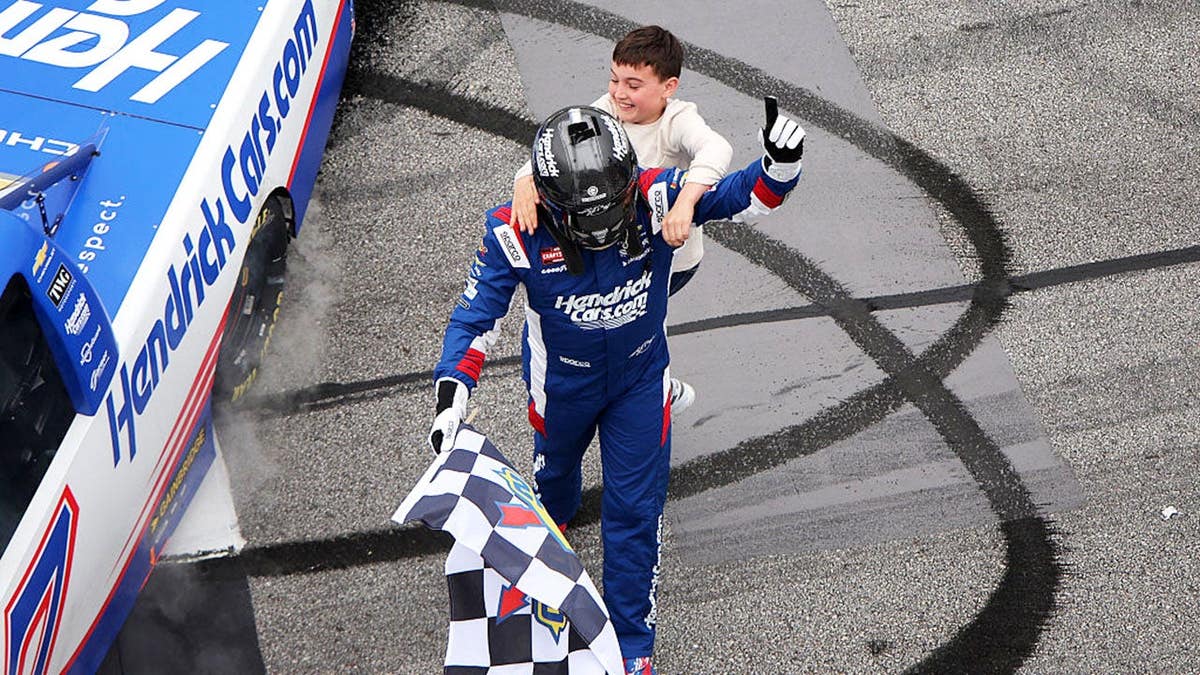 Kyle Busch standing with his son Brexton Busch at Echo Park Speedway