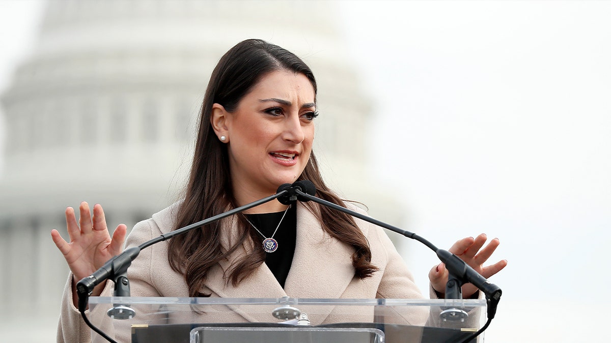 Rep. Sara Jacobs speaking at a podium in front of the U.S. Capitol Building