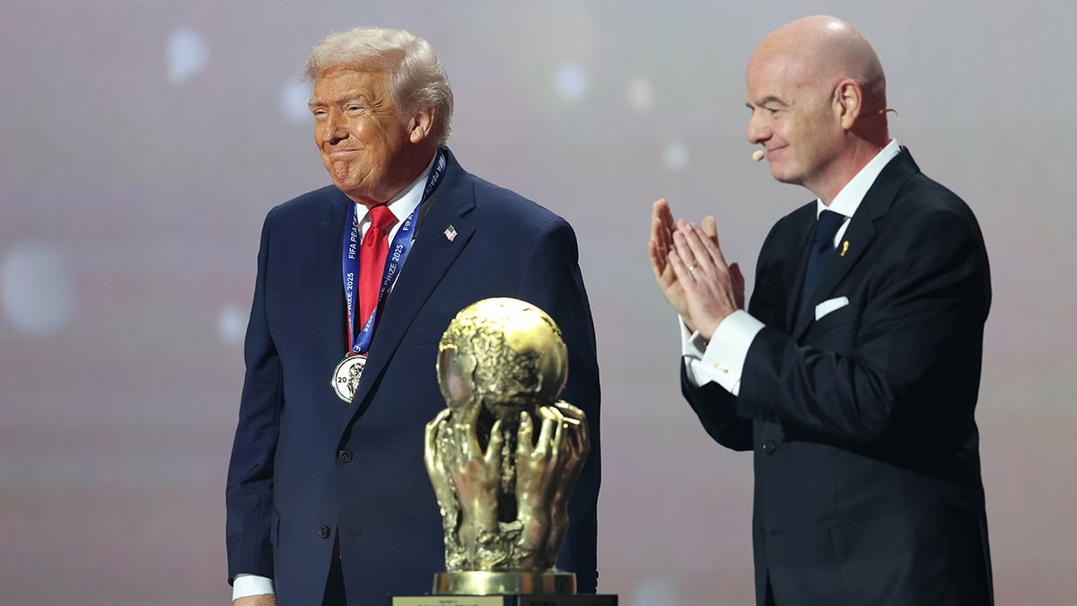 U.S. President Donald Trump receiving FIFA Peace Prize from Gianni Infantino on stage.