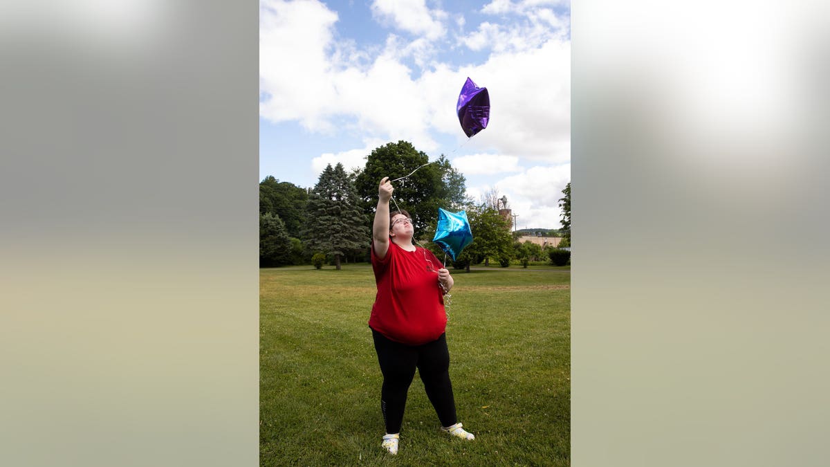 Kristan Newell writes on balloons before releasing them at Lazybrook Park in Tunkhannock, Pennsylvania