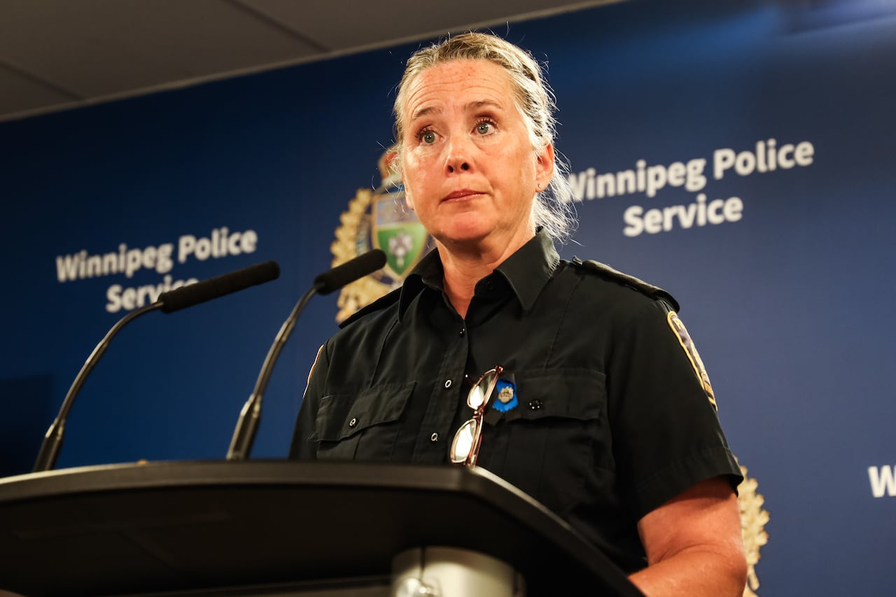 A police officer stands at a microphone on a podium.