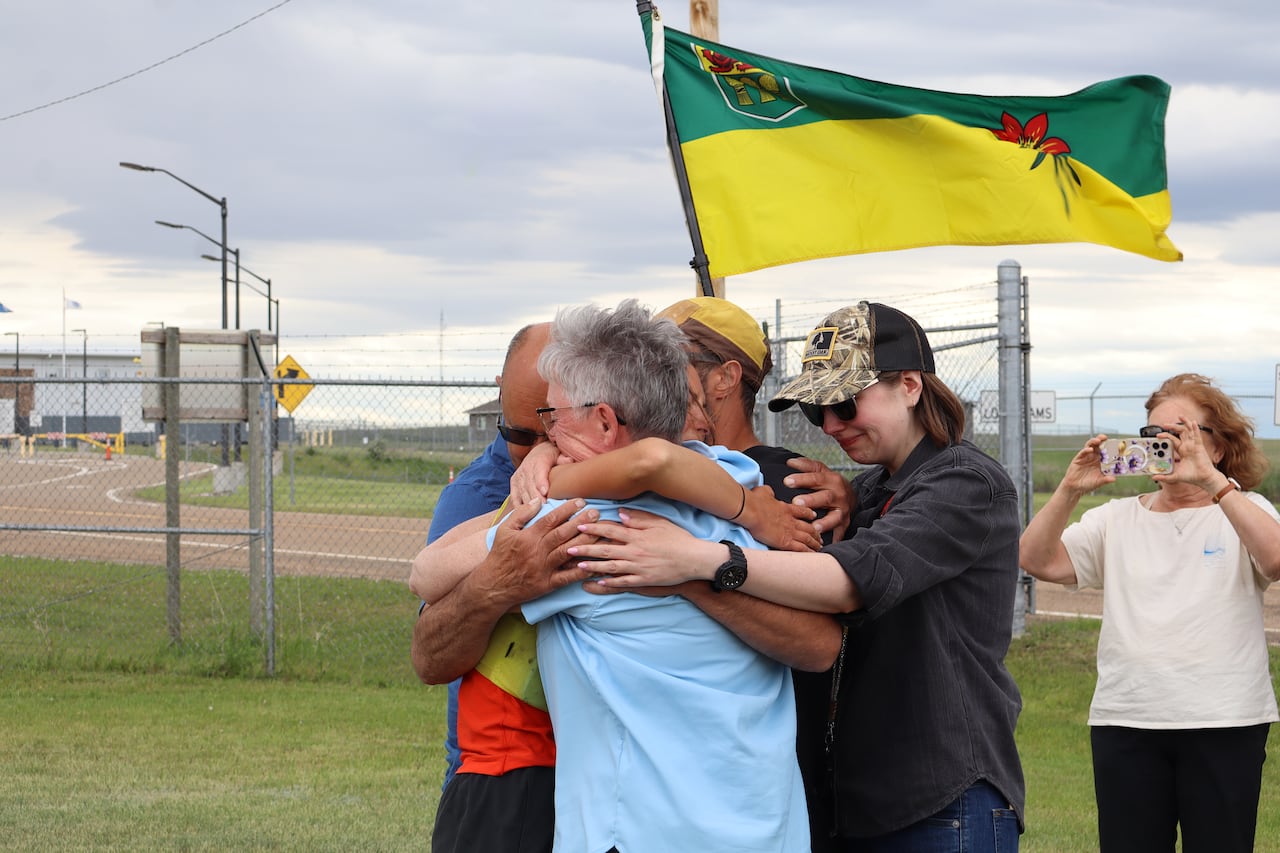People hugging with Saskatchewan flag