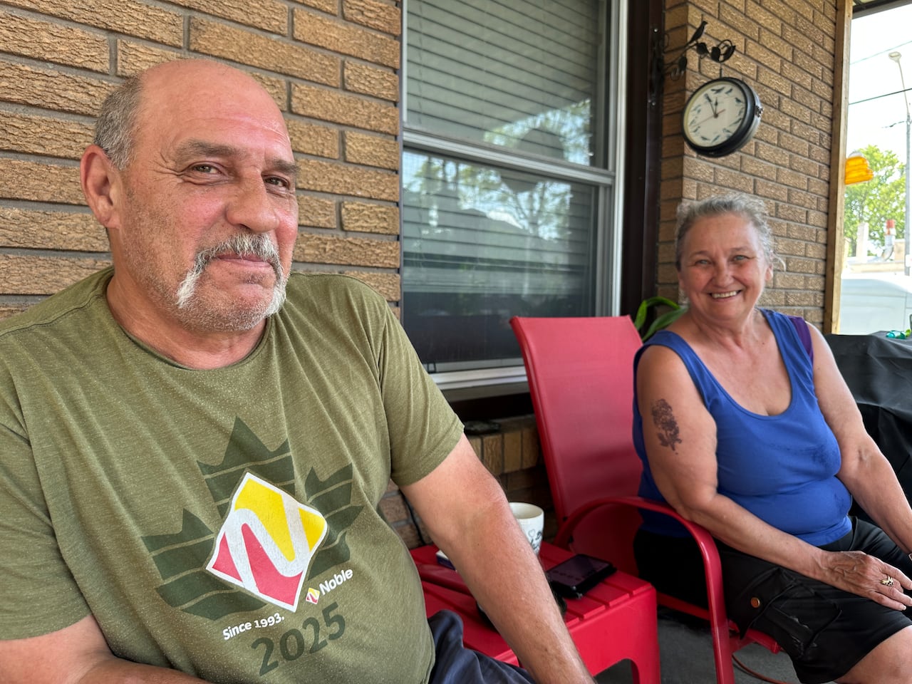A couple sitting in the front yard.