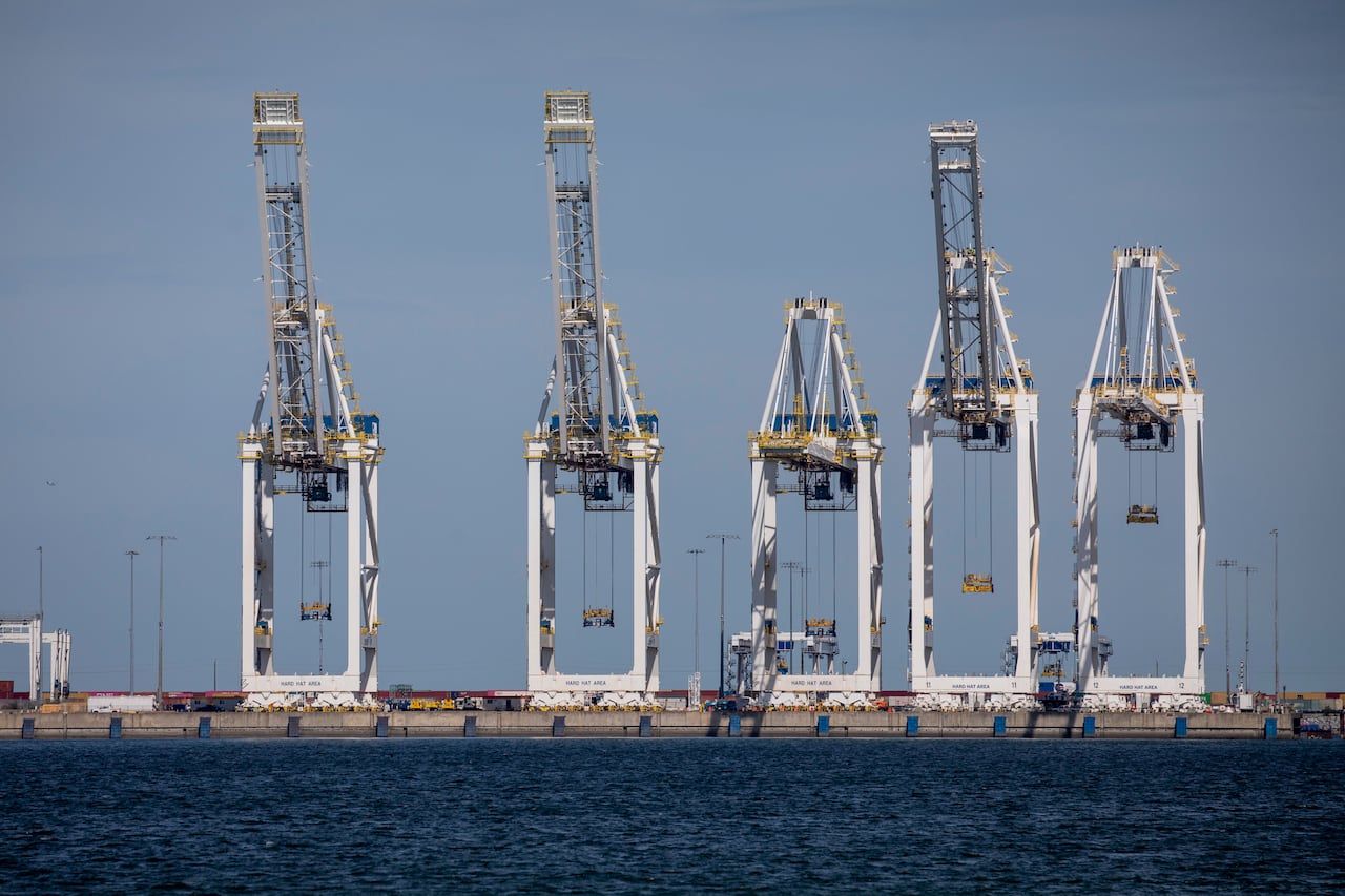 A number of cargo loaders are seen at a port.