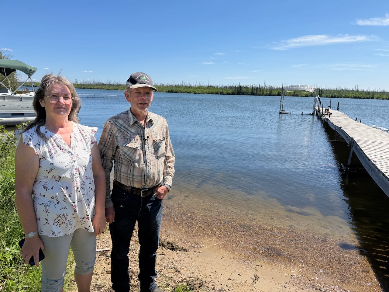 Two people stand by the water.