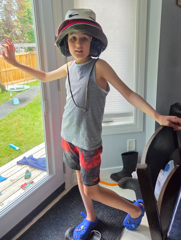 A boy wearing multiple hats.
