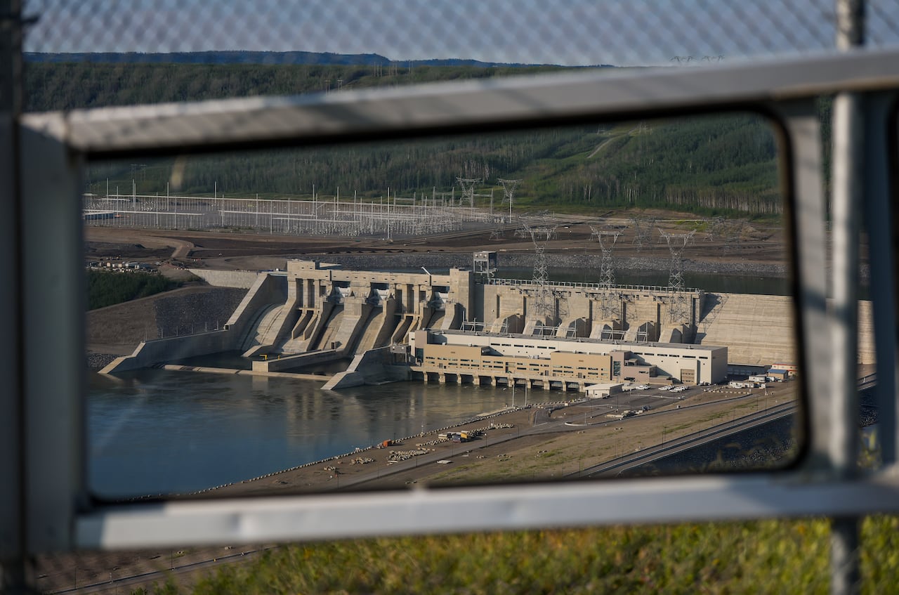 A wide shot of the John Horgan Dam from a distance and through a fence.