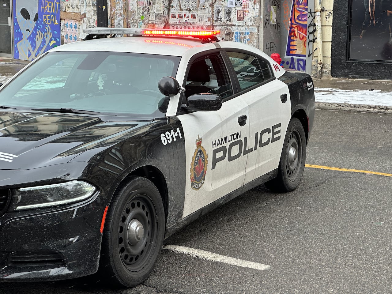 A police car parked perpendicularly blocking a city street.
