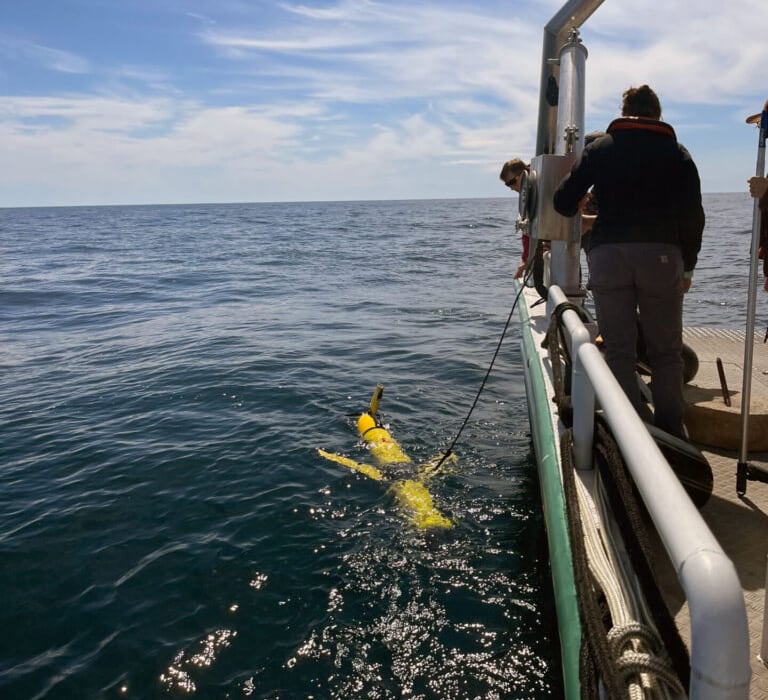 An autonomous underwater glider is put into one of the Great Lakes to gauge temperatures and collect other environmental science data.