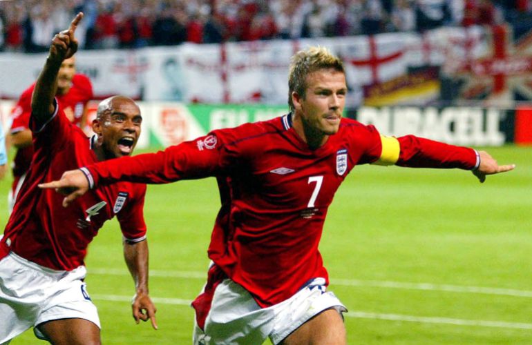 England captain David Beckham (R) runs in celebration with team mate Trevor Sinclair after scoring from the penalty spot against [Argentina] during their group F World Cup Finals match at the Sapporo Dome stadium June 7, 2002. [England were awarded a penalty after striker Michael Owen was tripped inside the penalty area.]