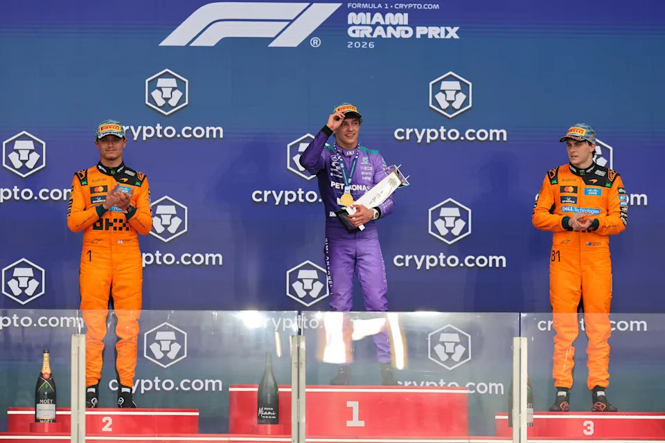 May 3, 2026; Miami Gardens, FL, USA; Mercedes driver Kimi Antonelli (center), McLaren driver Lando Norris (left) and McLaren driver Oscar Piastri (right) react on the stage for the Crypto.com Miami Grand Prix at Miami International Autodrome.