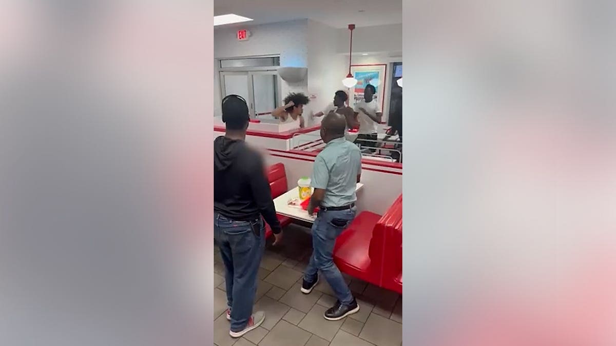 People fighting inside an In-N-Out Burger