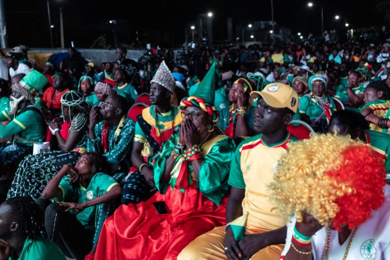 Senegal supporters react after their team lost the 2026 World Cup round of 32 football match against Belgium as they watch the game at the FIFA Fan Zone at the Place de l'Obelisque in Dakar on July 1, 2026.