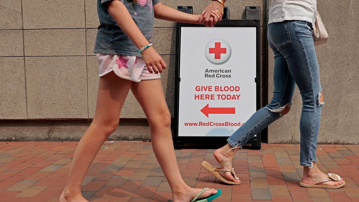 Pedestrians walk past the American Red Cross Blood Donation Center.
